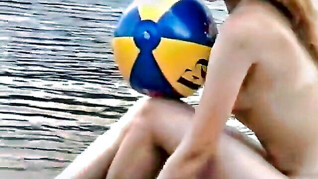 two nude females on a beach playing catch and applying sunscreen : dickinson_gunner