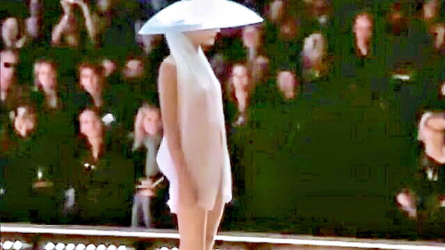 a stunning model with a unique hat strolls down the runway in the buff diverting attention from the designers newest collection : alvina_parker